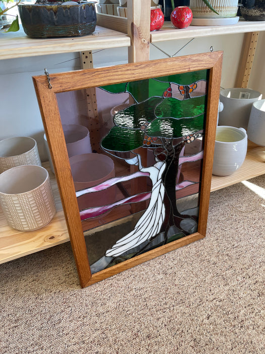 Vintage Stained Glass Art Panel Depicting Woman in Flowing White Dress Beneath Tree with Fruit, Framed in Wooden Oak Toned Frame