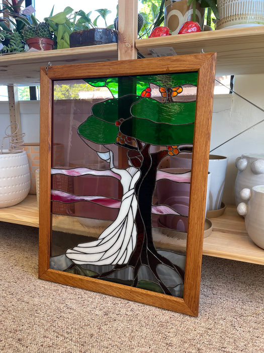 Vintage Stained Glass Art Panel Depicting Woman in Flowing White Dress Beneath Tree with Fruit, Framed in Wooden Oak Toned Frame