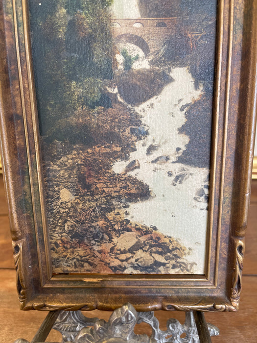 Vintage Tinted Landscape Photograph of Waterfall and Stone Bridge in Ornate