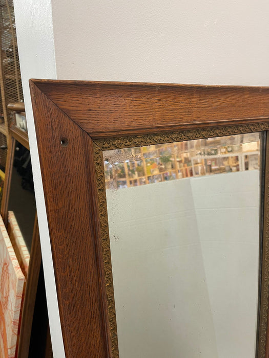 Antique Style Wall Mirror With Ornate Golden Toned Banding Around the Frame.