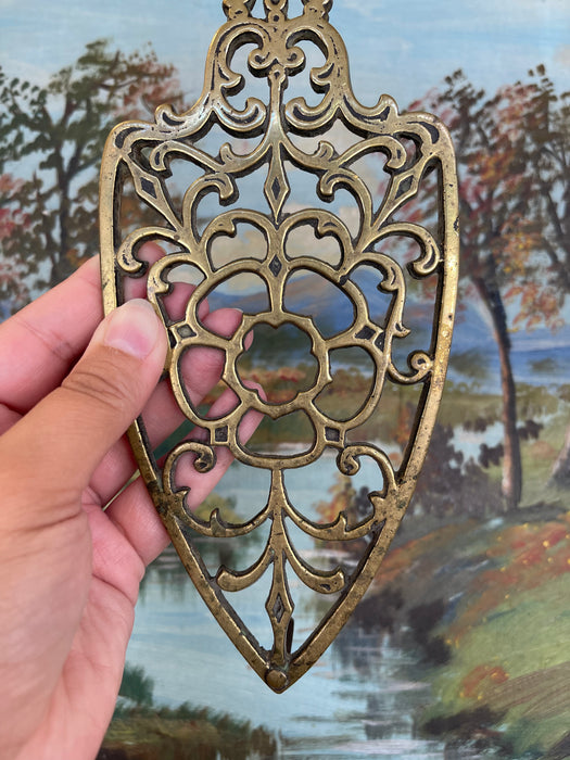 Brass Toned Cast Trivet with Ornate Victorian Design.
