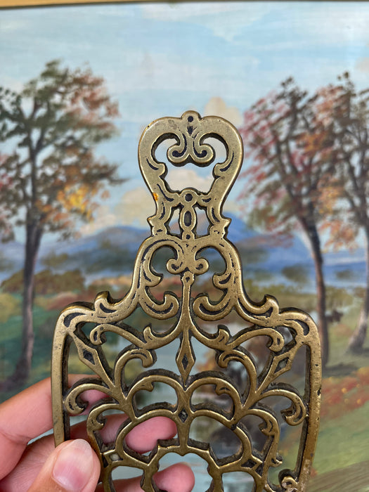 Brass Toned Cast Trivet with Ornate Victorian Design.