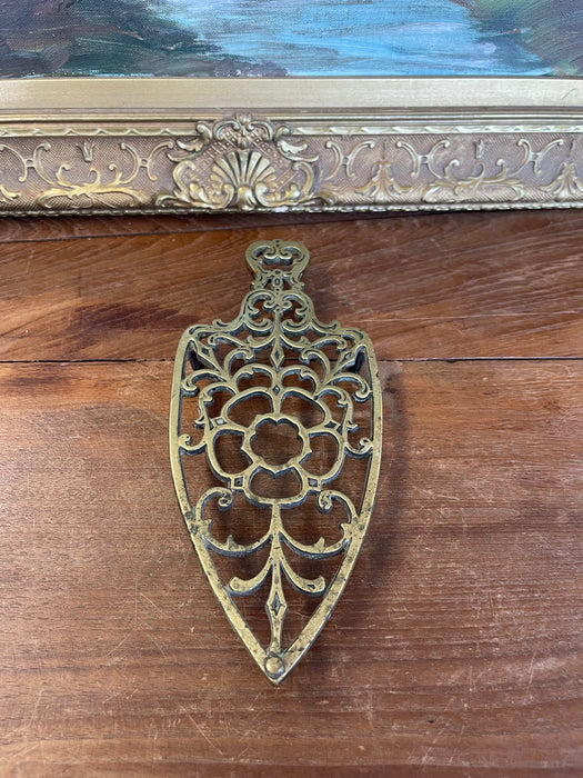 Brass Toned Cast Trivet with Ornate Victorian Design.