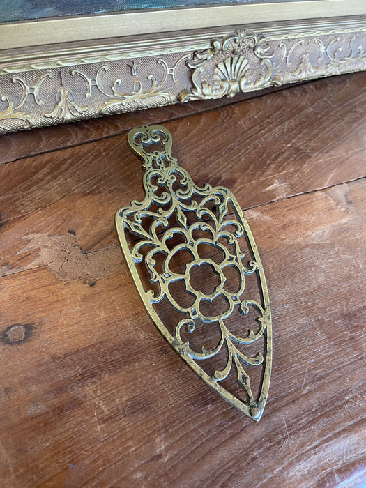 Brass Toned Cast Trivet with Ornate Victorian Design.
