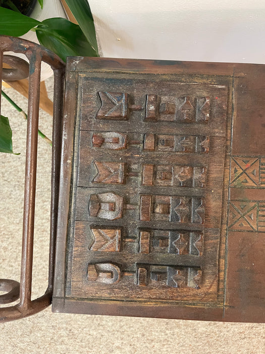 Vintage Hand-Carved Wood and Wrought Iron Console Table with Tribal Motifs and Scrollwork Arms
