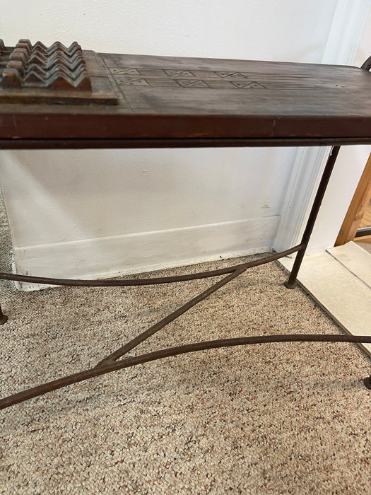 Vintage Hand-Carved Wood and Wrought Iron Console Table with Tribal Motifs and Scrollwork Arms