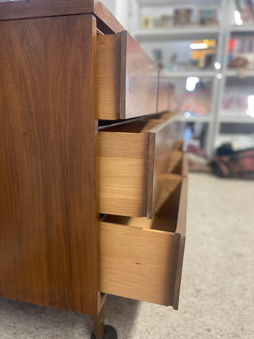 Mid-Century Modern Likely Walnut Nine-Drawer Dresser with Sculpted Pulls, Dovetail Drawers, and Tapered Legs